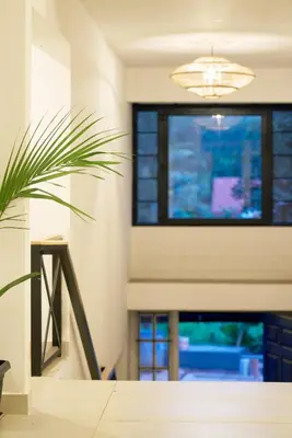 a living room with a potted plant and a window at Okka by Raho - A colonial style villa in Coorg in Siddapur