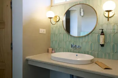 a bathroom with a sink and a mirror on a counter at Okka by Raho - A colonial style villa in Coorg in Siddapur