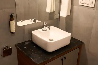 a bathroom with a white sink and a mirror at Nila by Raho - Secluded Villa with Estate View in Siddapur