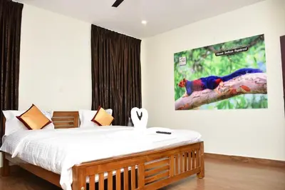 a bedroom with a bed and a painting on the wall at LaFiesta in Kodaikānāl