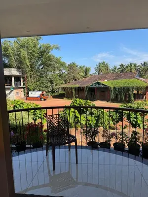 a chair sitting on a balcony with a building at Calm Serenity Homestay in Kozhikode