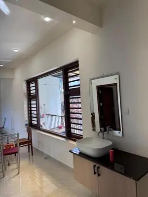a bathroom with a sink and a large window at Calm Serenity Homestay in Kozhikode