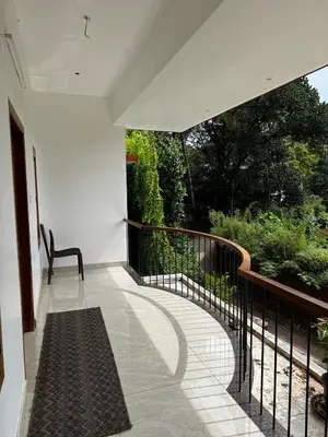 a balcony of a house with a bench on it at Calm Serenity Homestay in Kozhikode