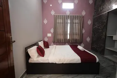 a bedroom with a bed with red pillows at Vani Vilas Luxury Villa in Mysore