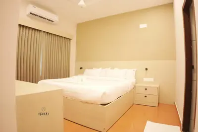 a bedroom with a white bed and a window at Hotel Spacio in Kozhikode