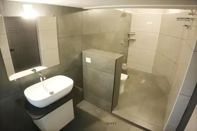 a bathroom with a sink and a toilet at Hotel Spacio in Kozhikode