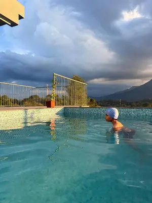 a woman in a swimming pool with a towel on her head at Idam home stay in Wayanad