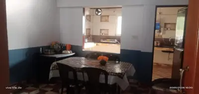 a table in a small room with a table and chairs at Varshini home stay in Kotagiri