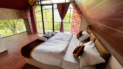 a large bed in a room with a window at Era Resort Slope Stay in Kodaikānāl