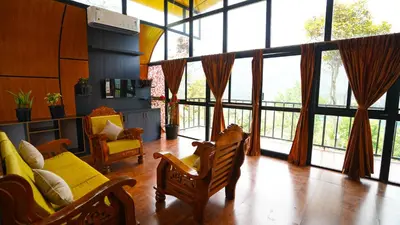 a living room with a couch and chairs and large windows at Era Resort Slope Stay in Kodaikānāl