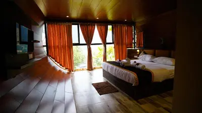 a bedroom with a large bed and large windows at Era Resort Slope Stay in Kodaikānāl