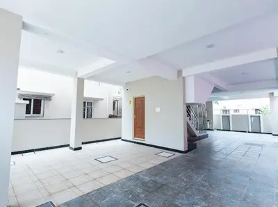 a large room with white walls and a wooden door at Sree Home Stay and Service Apartment in Coimbatore