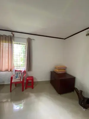 a living room with a red chair and a window at Coorg jungle Cottage in Kushālnagar