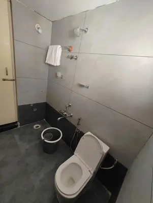 a small bathroom with a toilet and a bucket at Nirmala Dhama Farmstay - Serene Family Retreat