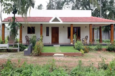a small white house with a red roof at Nirmala Dhama Farmstay - Serene Family Retreat