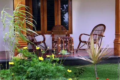 three chairs sitting on the porch of a house at Nirmala Dhama Farmstay - Serene Family Retreat
