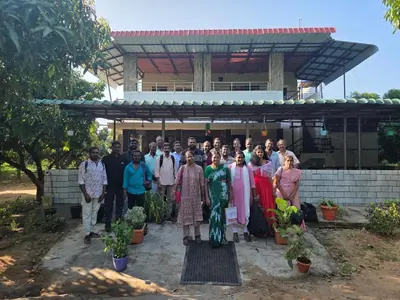 a group of people standing in front of a building at Mango Bite Farmstay in Pollāchi