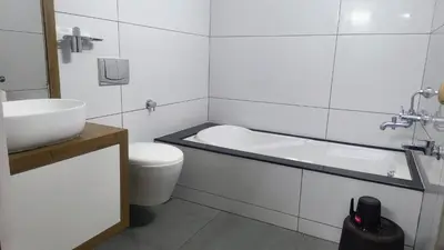 a bathroom with a tub and a toilet and a sink at Salisbury Manor Heritage Inn in Marayoor