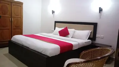 a bedroom with a large bed with red and white pillows at Salisbury Manor Heritage Inn in Marayoor