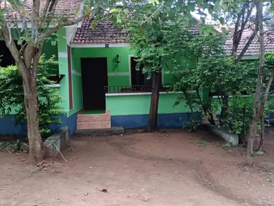 a house with a green and blue facade at Jungle Mist Cottages in Masinagudi
