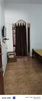a room with a bed and a curtain in it at Jungle Mist Cottages in Masinagudi