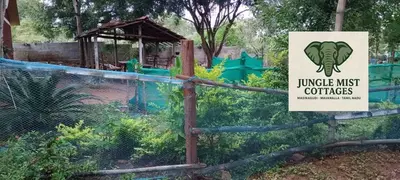 a sign on a fence in front of a park at Jungle Mist Cottages in Masinagudi