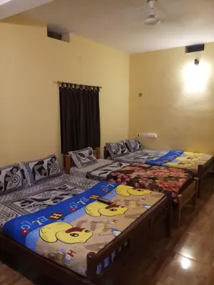 a room with three beds with cartoon faces on them at Jungle Mist Cottages in Masinagudi