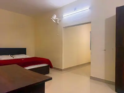 a bedroom with a bed with a red blanket at Wayanad Shas Villa in Padinjarathara