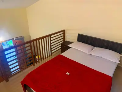 a bedroom with a large bed with a red blanket at Wayanad Shas Villa in Padinjarathara