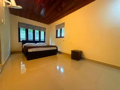 a bedroom with a bed in a room with yellow walls at Wayanad Shas Villa in Padinjarathara