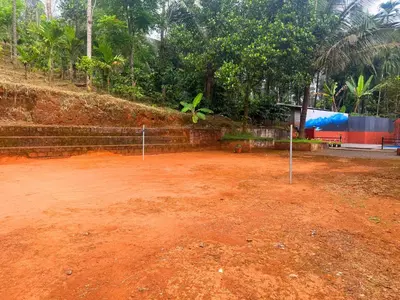 a tennis court with red dirt on the ground at Wayanad Shas Villa in Padinjarathara