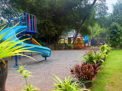 a playground with a blue slide in a park at Wayanad Shas Villa in Padinjarathara
