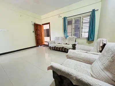 a living room with two couches and a couch at Raya 2 bhk flats in Mysore