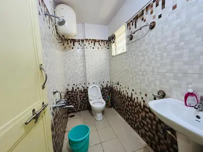 a small bathroom with a toilet and a sink at Raya 2 bhk flats in Mysore