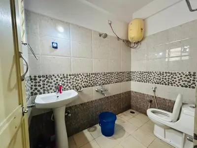 a bathroom with a sink and a toilet at Raya 2 bhk flats in Mysore