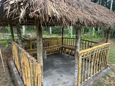 a hut with a bridge with a grass roof at Vathika Villa in Sultan Bathery