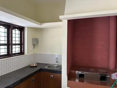 a kitchen with a sink and a red wall at Vathika Villa in Sultan Bathery