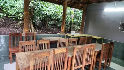 a wooden table and chairs in a room at Finca Backwater Homestay in Suntikoppa