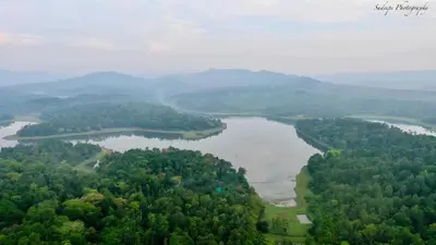 an aerial view of a river with trees and mountains at Finca Backwater Homestay in Suntikoppa