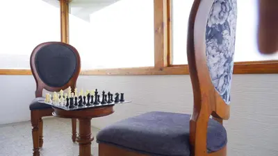 two chairs and a chess board with candles in a room at 3 Bhk Villa Ooty - Casa de Amor by EBR in Ooty