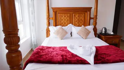 a bed with white sheets and a red blanket at 3 Bhk Villa Ooty - Casa de Amor by EBR in Ooty