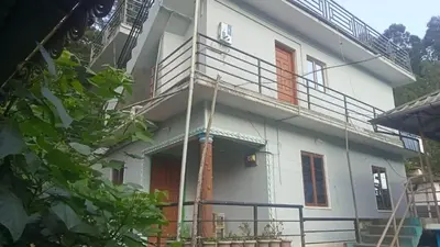 a white house with stairs on the side of it at Shobha home stay in Vattavada