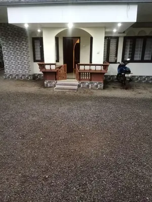 a house with two benches in front of it at Winter Valley Home Stay in Vythiri