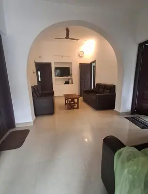 a living room with two couches and a table at Winter Valley Home Stay in Vythiri