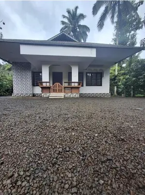 a house with a gravel driveway in front of it at Winter Valley Home Stay in Vythiri