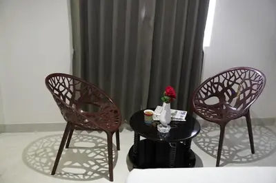 two chairs and a table in front of a curtain at KK Service Suites in Coimbatore