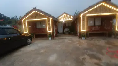 a couple of huts with lights on them at Magizh Kudil The Mud House in Marayoor