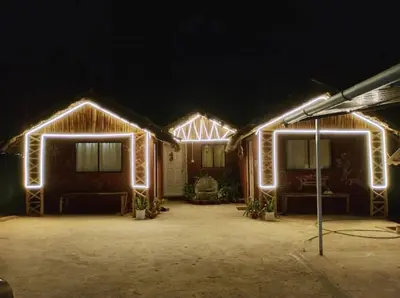 a house with lights on the front at night at Magizh Kudil The Mud House in Marayoor