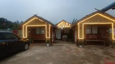 a group of huts with lights on them at Magizh Kudil The Mud House in Marayoor