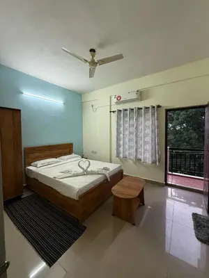 a bedroom with a bed and a window at Siddhartha Residency in Mysore